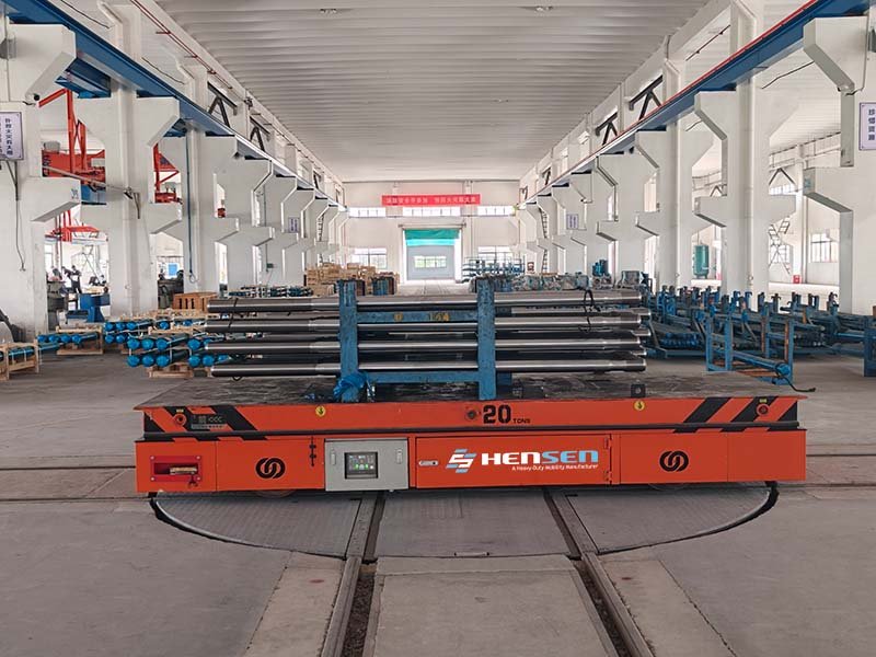20-ton orange RGV carrying metal shafts on a circular rail turntable