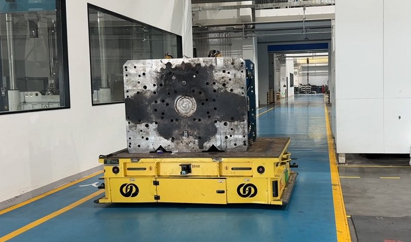 Project photo: a HENSEN heavy-duty AGV carrying a mold between production areas.